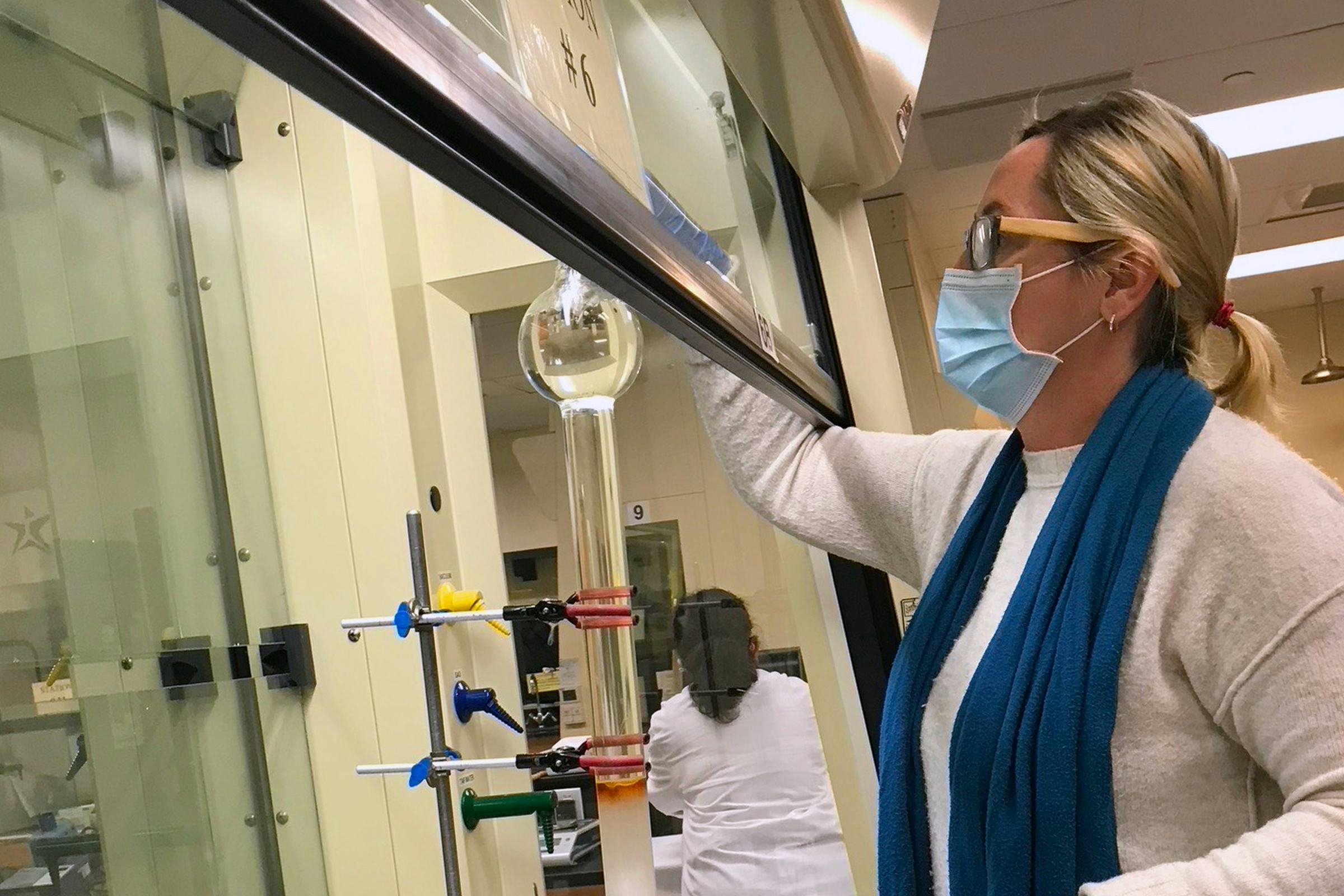 Shawn Amorde sets up a separations column which is used to purify chemicals after a reaction. Photo credit: Jackie Stamatedes