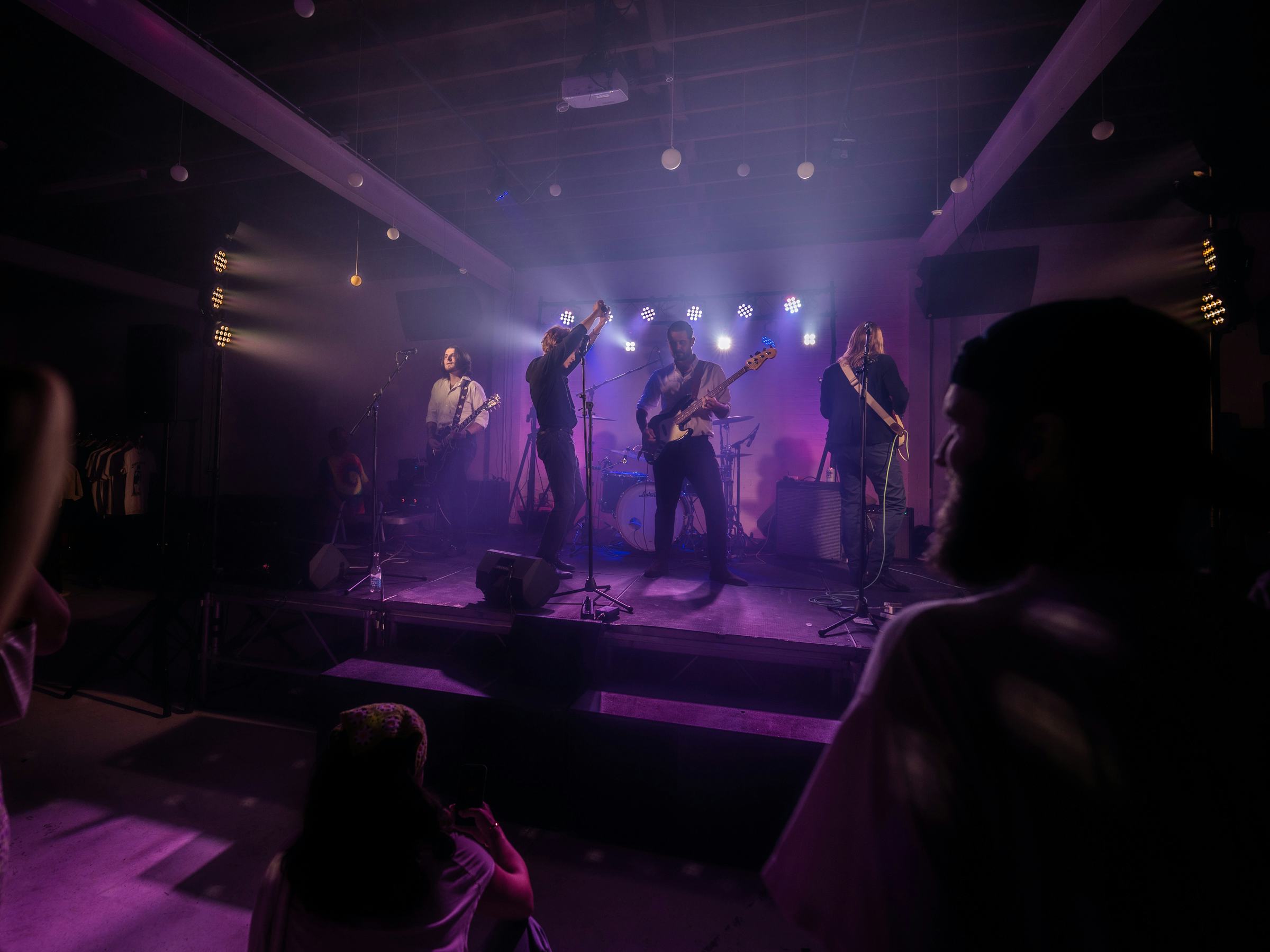 Photo of rock musicians performing on stage in a small music venue