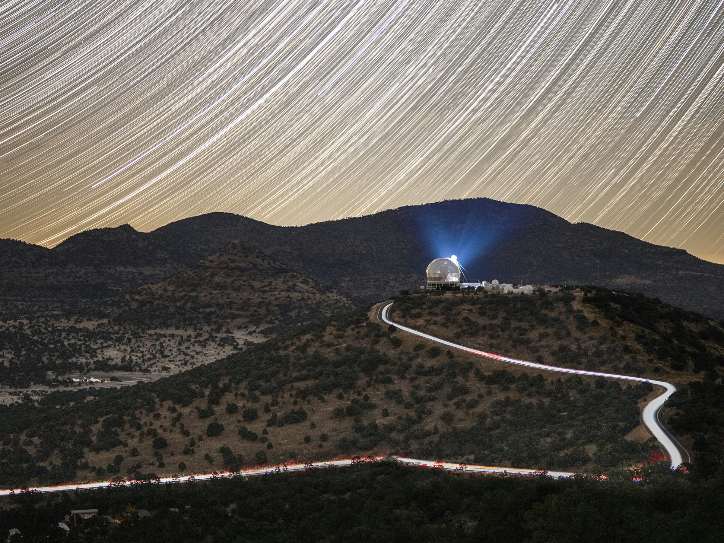 Time-lapse photo of the Hobby-Eberly Telescope in West Texas with star trails in the sky.