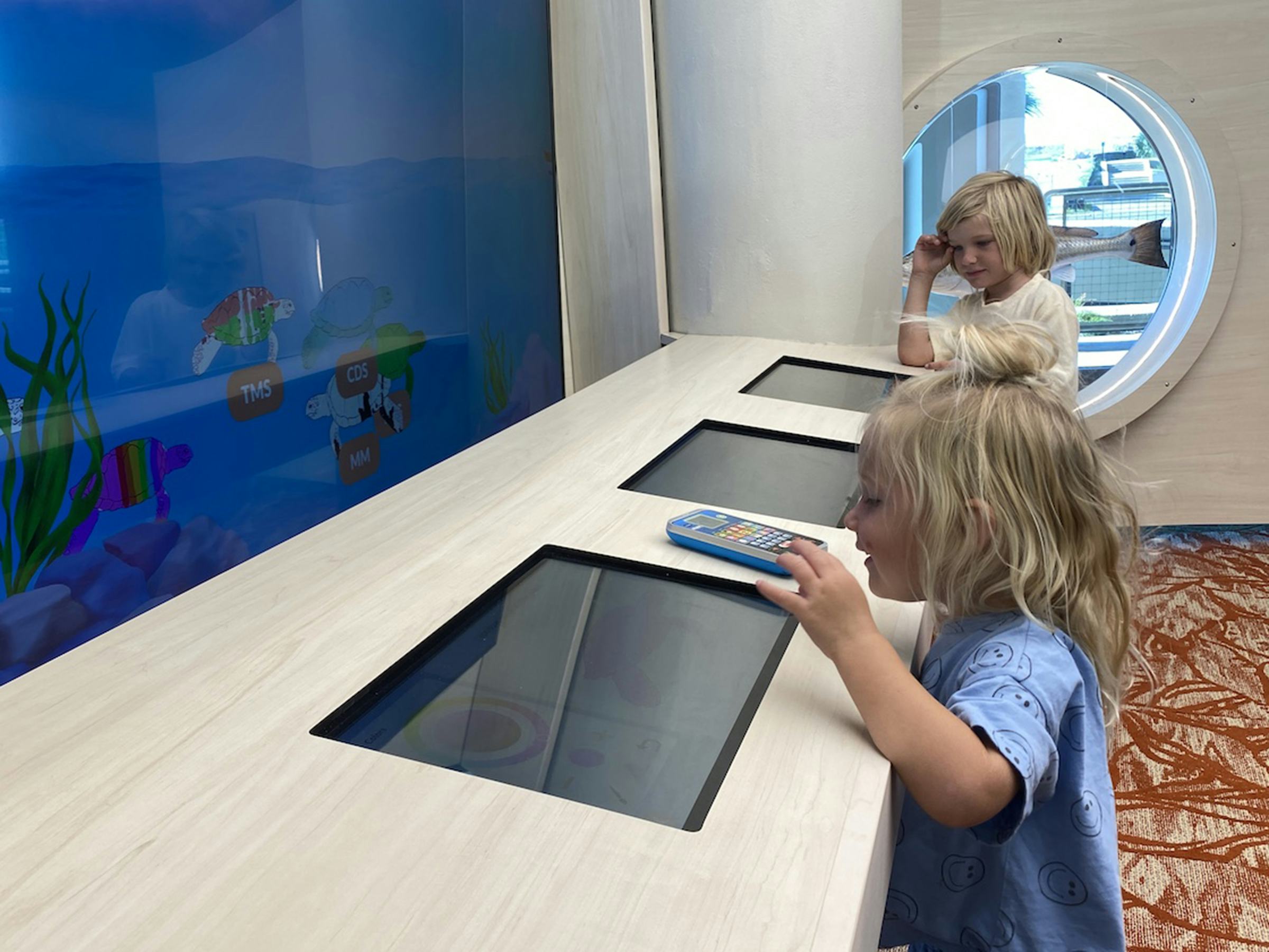 Photo of two children engaging with a digital interactive display at the Patton Center.