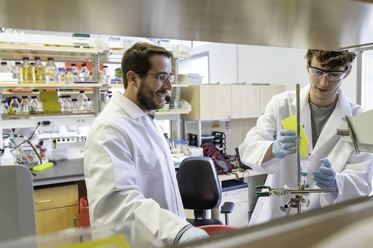 A professor and graduate student working in lab