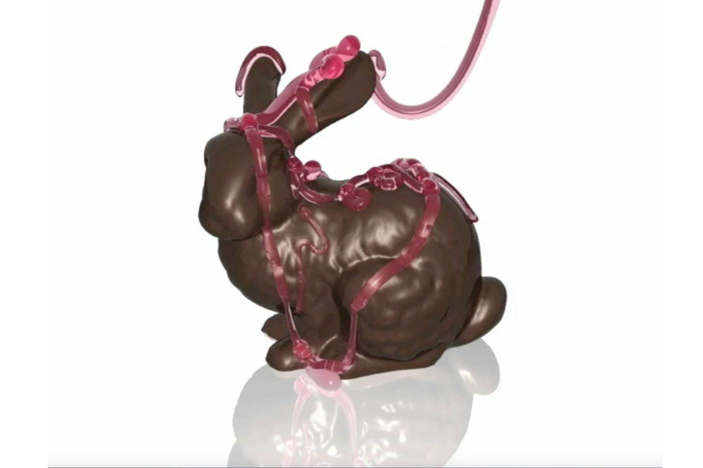A stream of raspbrerry sauce being poured over a chocolate bunny