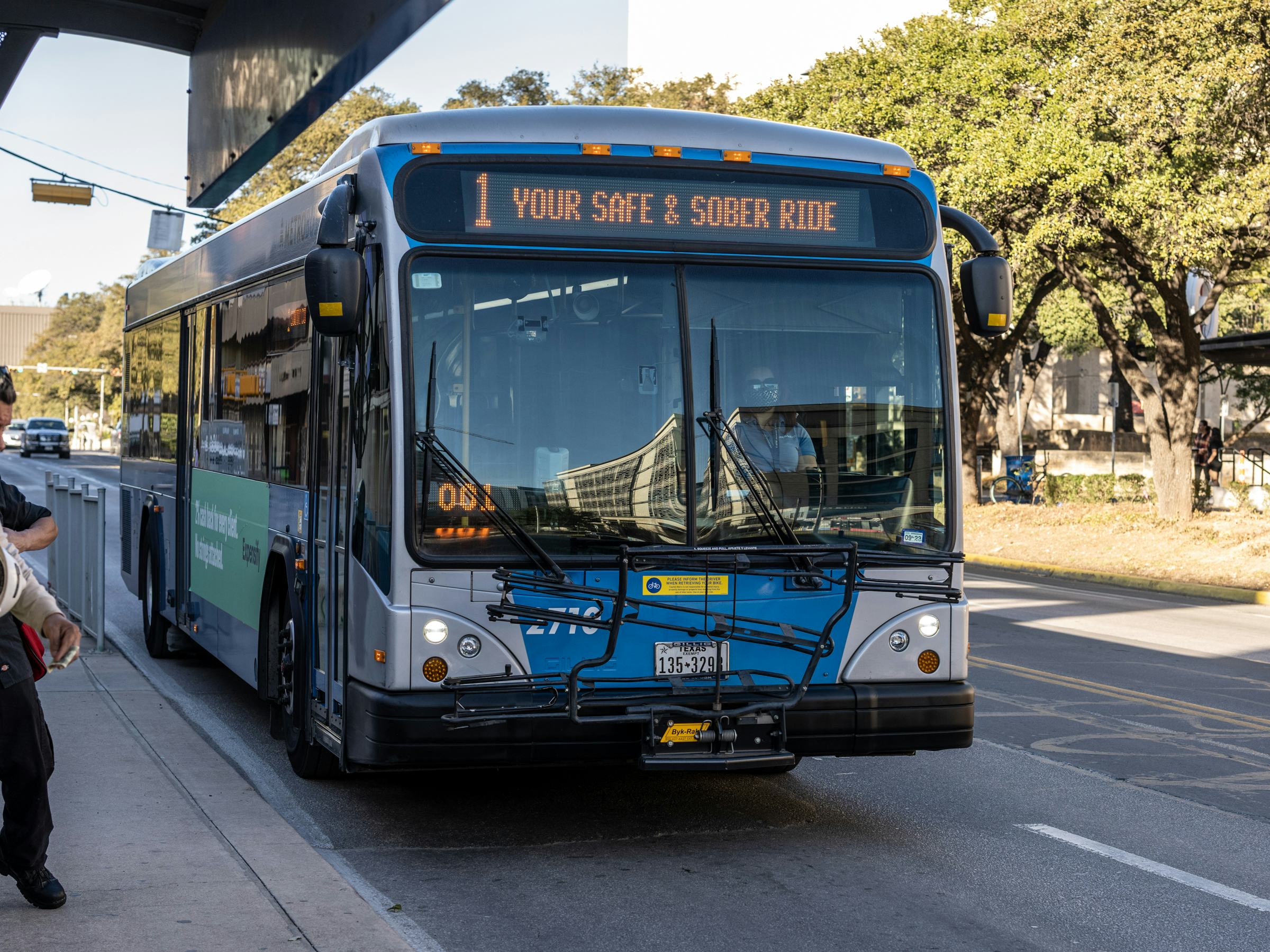A blue Austin Metro bus approaches the viewer