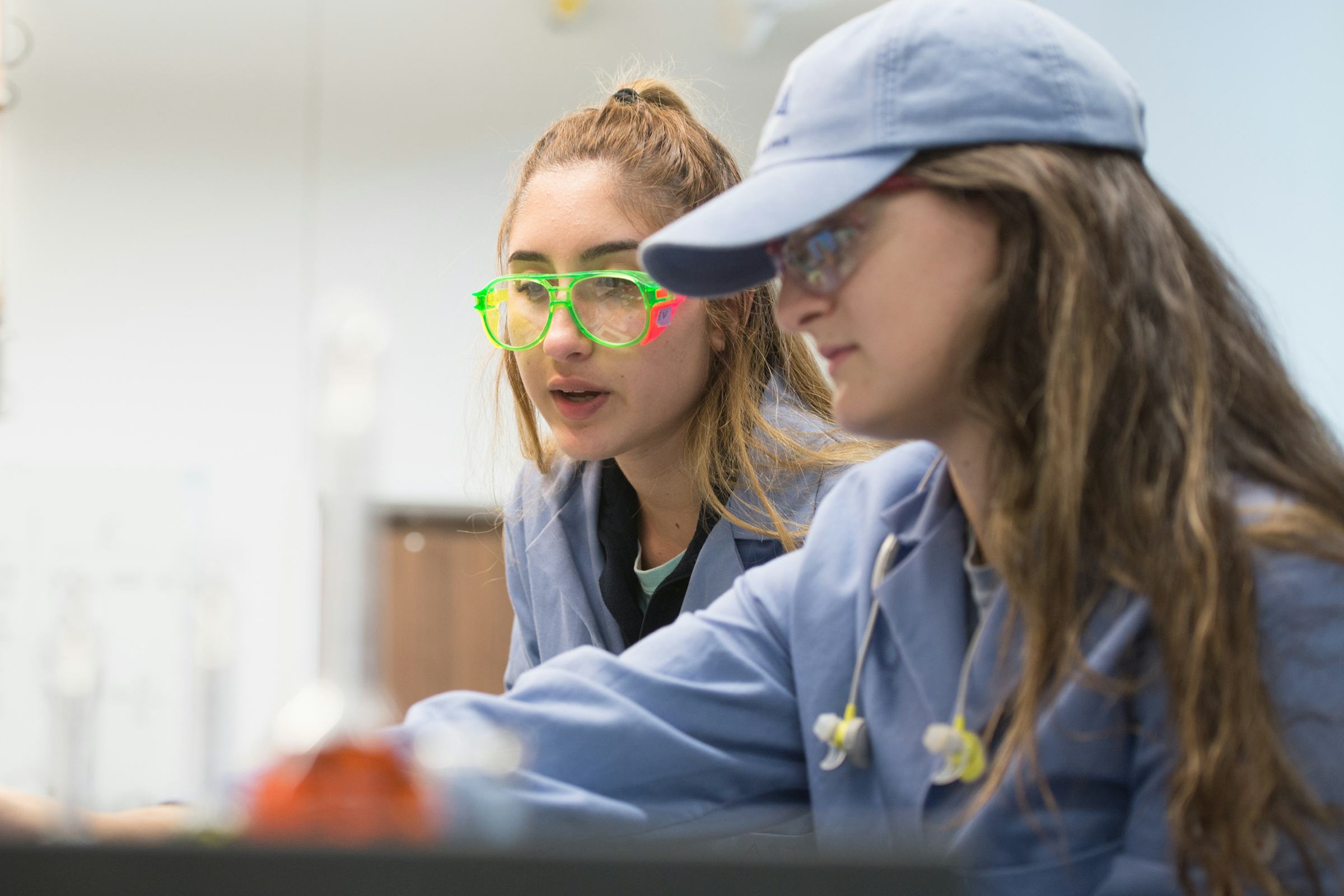 FRI researchers in a lab wearing goggles point to a finding