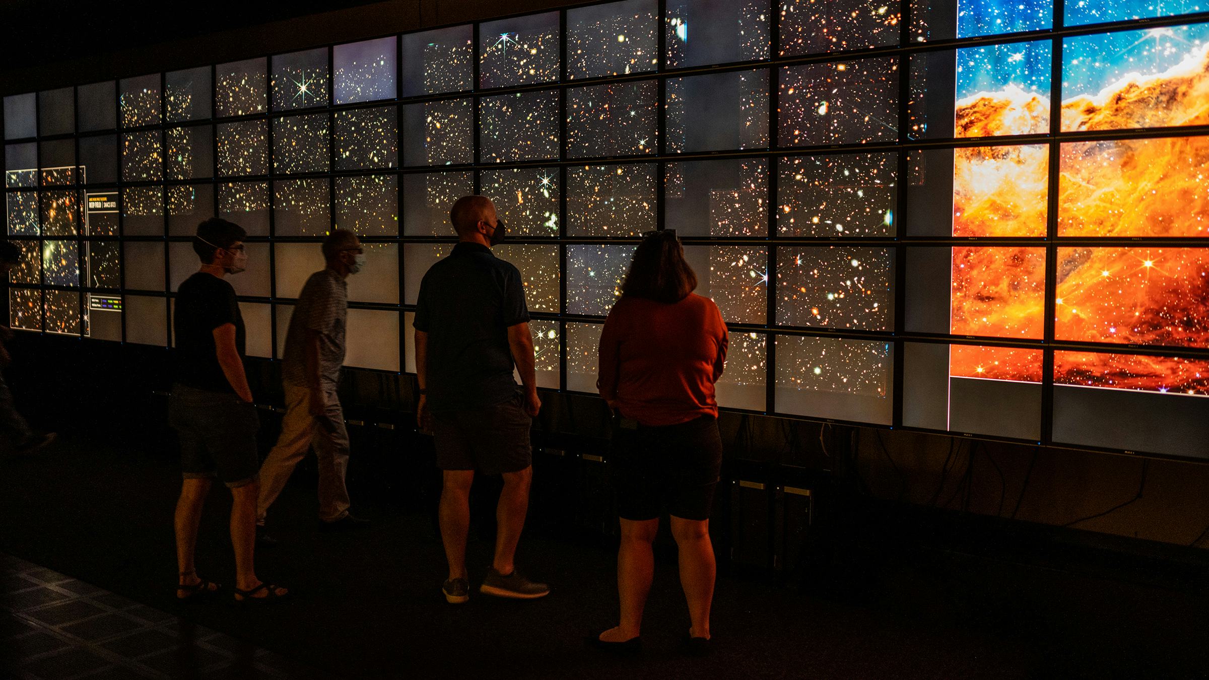 Individuals looking at a display of outer space