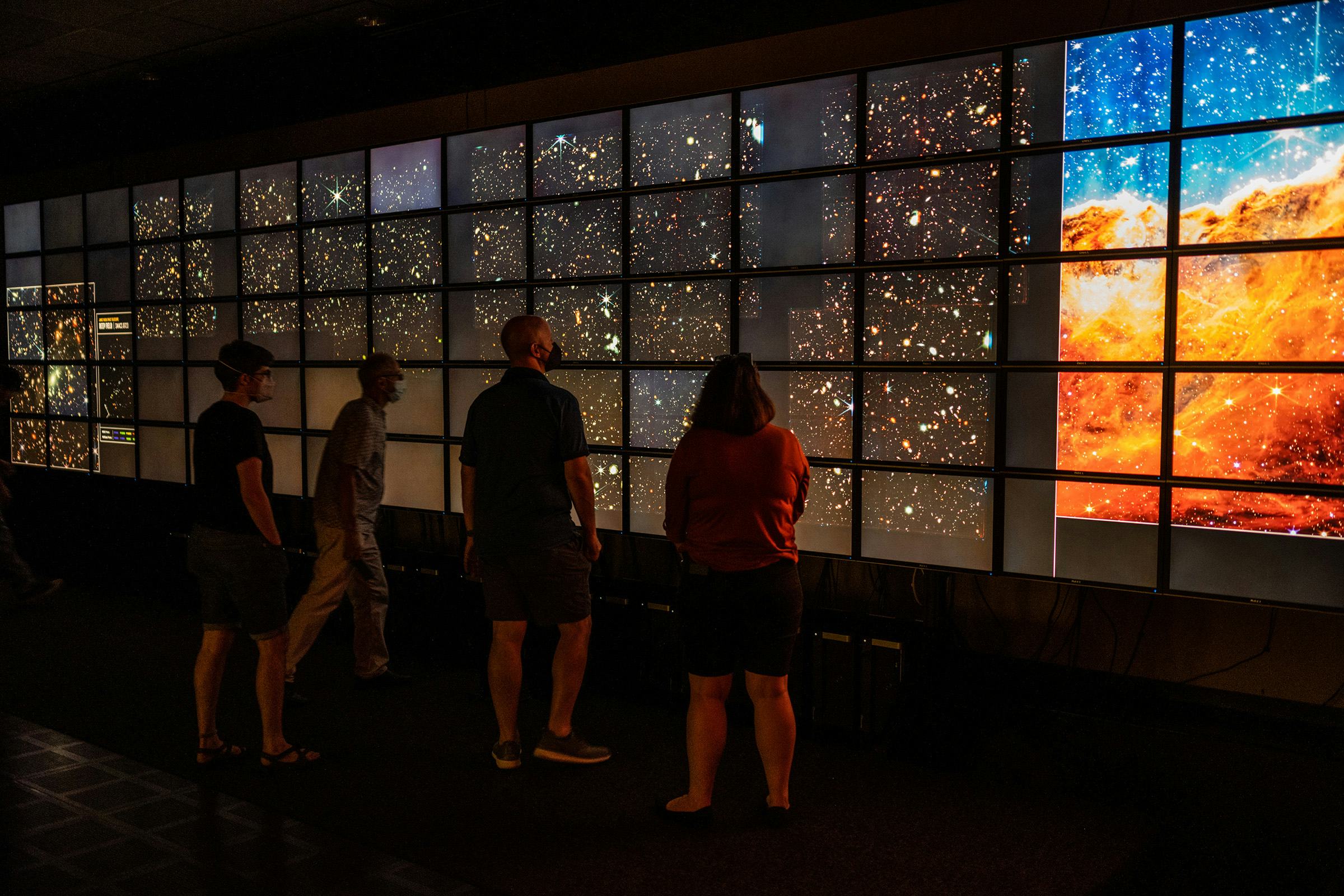 Individuals looking at a display of outer space