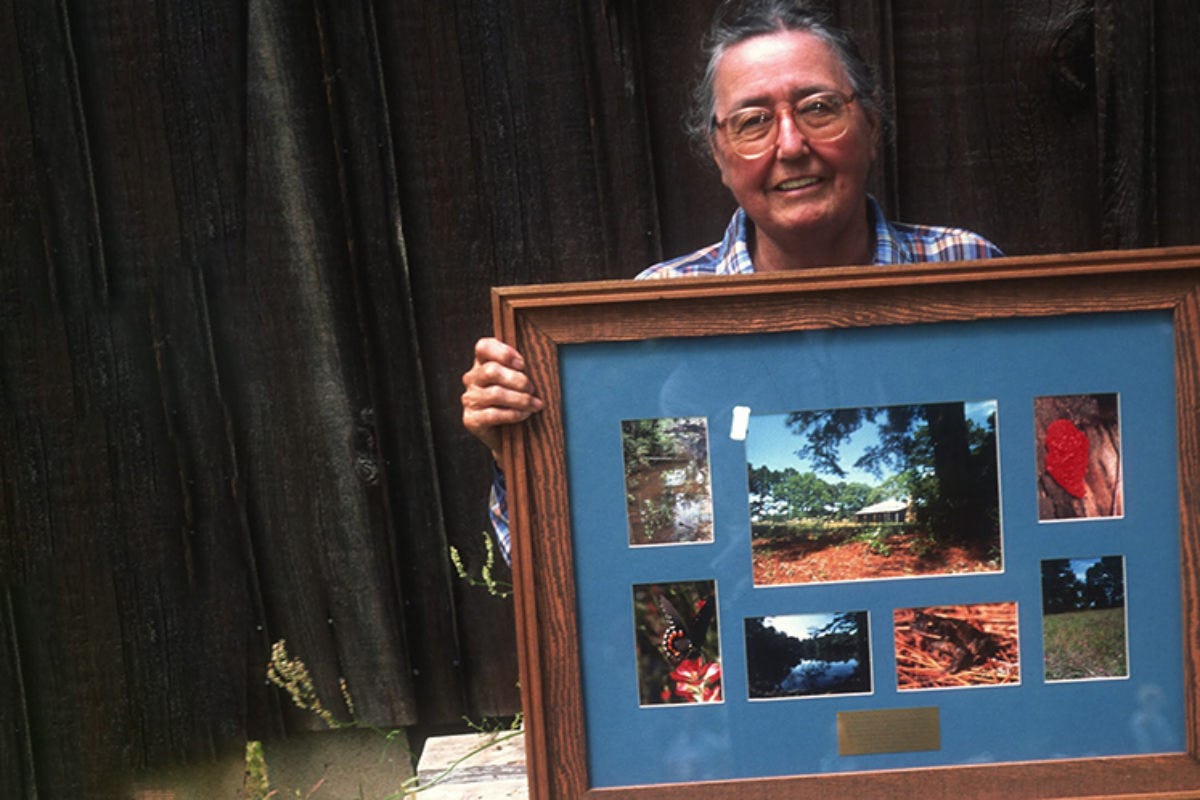 Casey Stengl holds a framed montage of plants and outdoor areas
